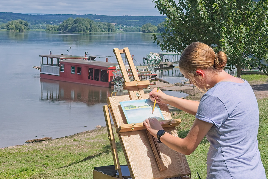 Ellie Michael painting outdoors along the Susquehanna River during a plein air painting session.